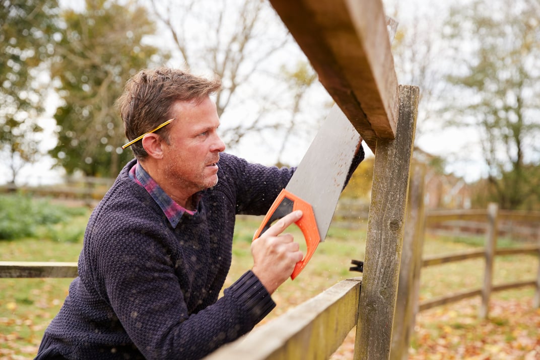 Mature Man Fixing Fence